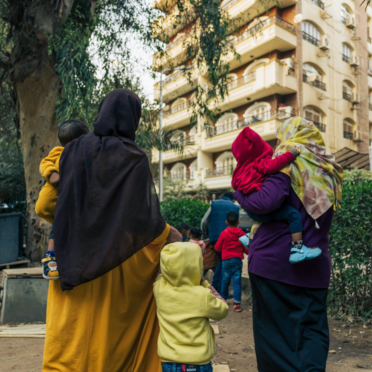 Rear view of two Palestinian women and their children in Cairo