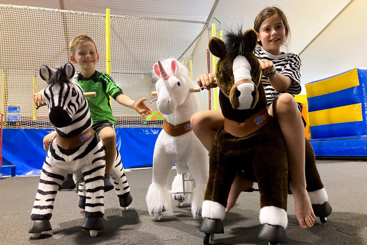 Zwei Kinder auf Spielzeugpferden