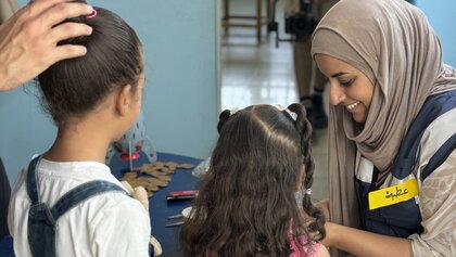 Eine Psychologin im Gespräch mit zwei palästinensischen Kindern