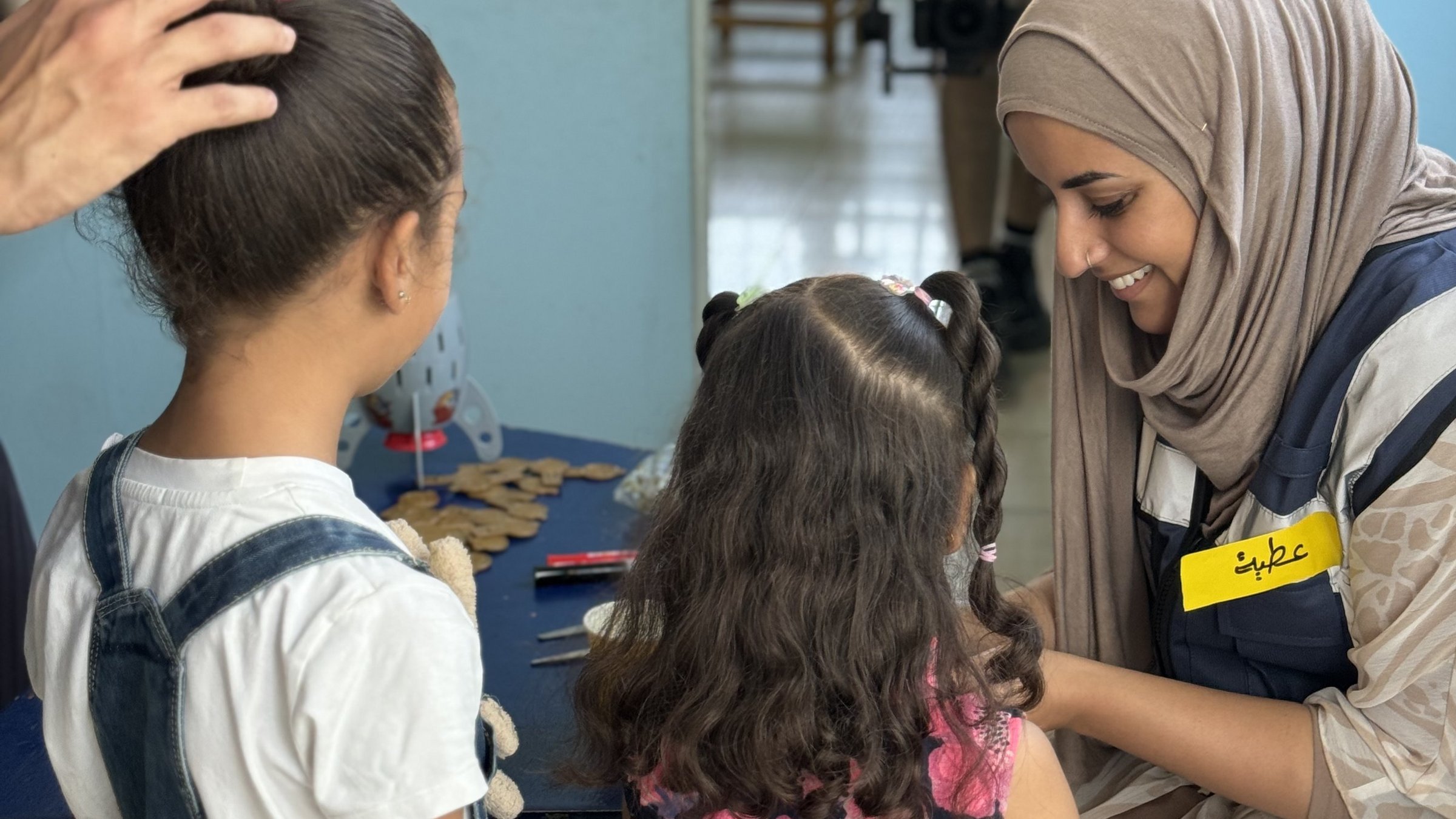 Eine Psychologin im Gespräch mit zwei palästinensischen Kindern