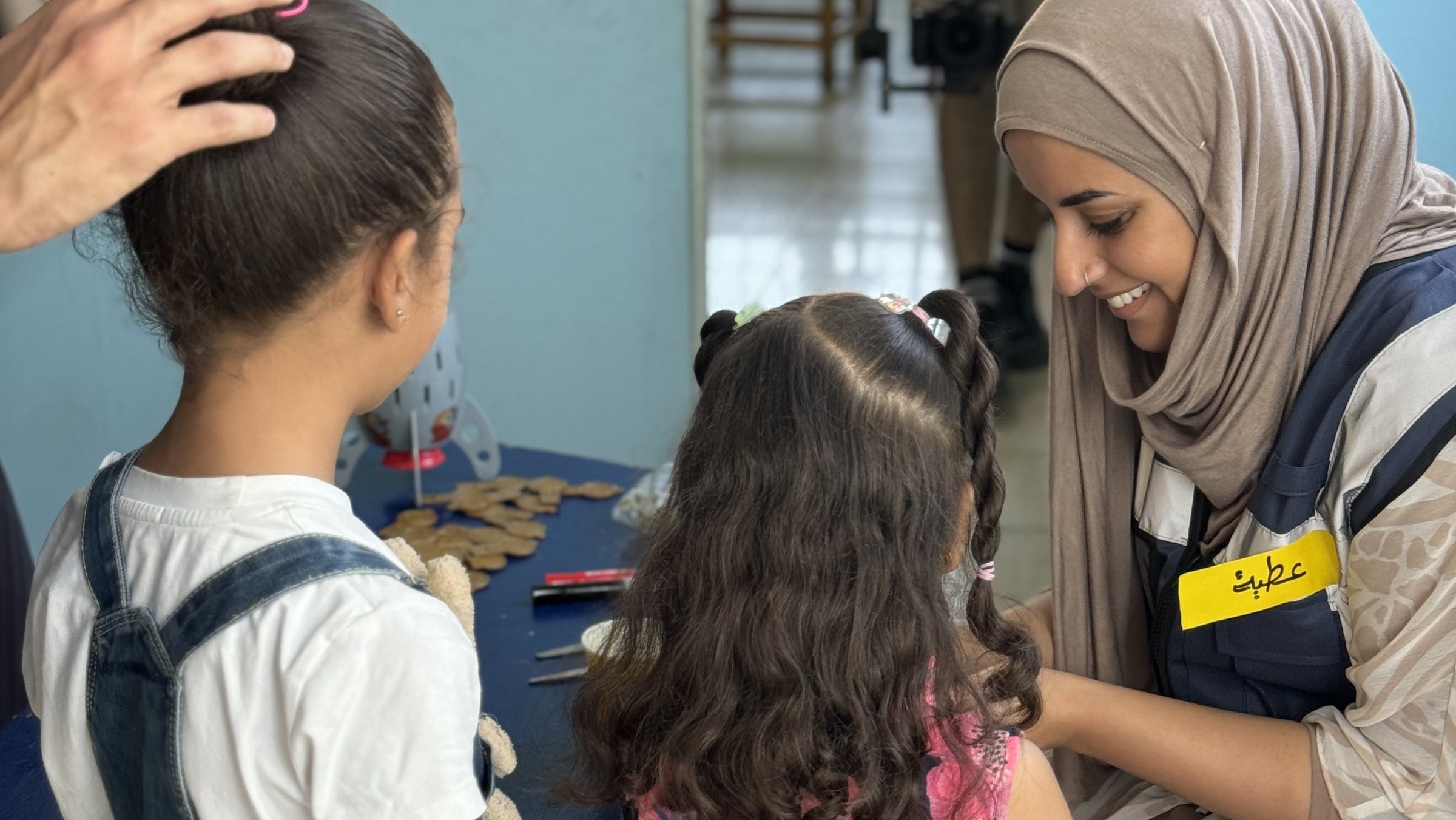 Eine Psychologin im Gespräch mit zwei palästinensischen Kindern