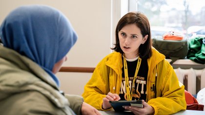Eine Mitarbeiterin der Hilfsorganisation Help im Gespräch mit einer Frau
