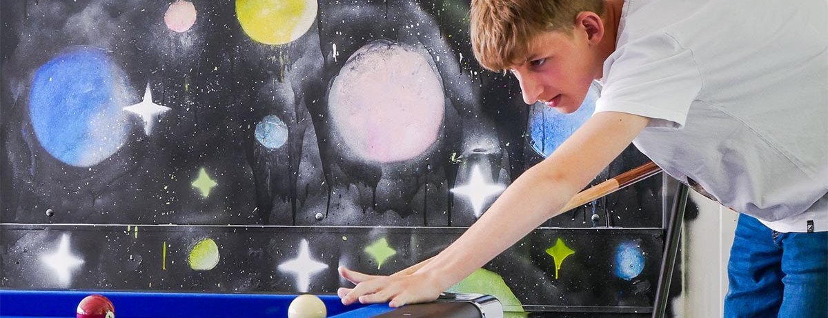 Ein Junge spielt Billard