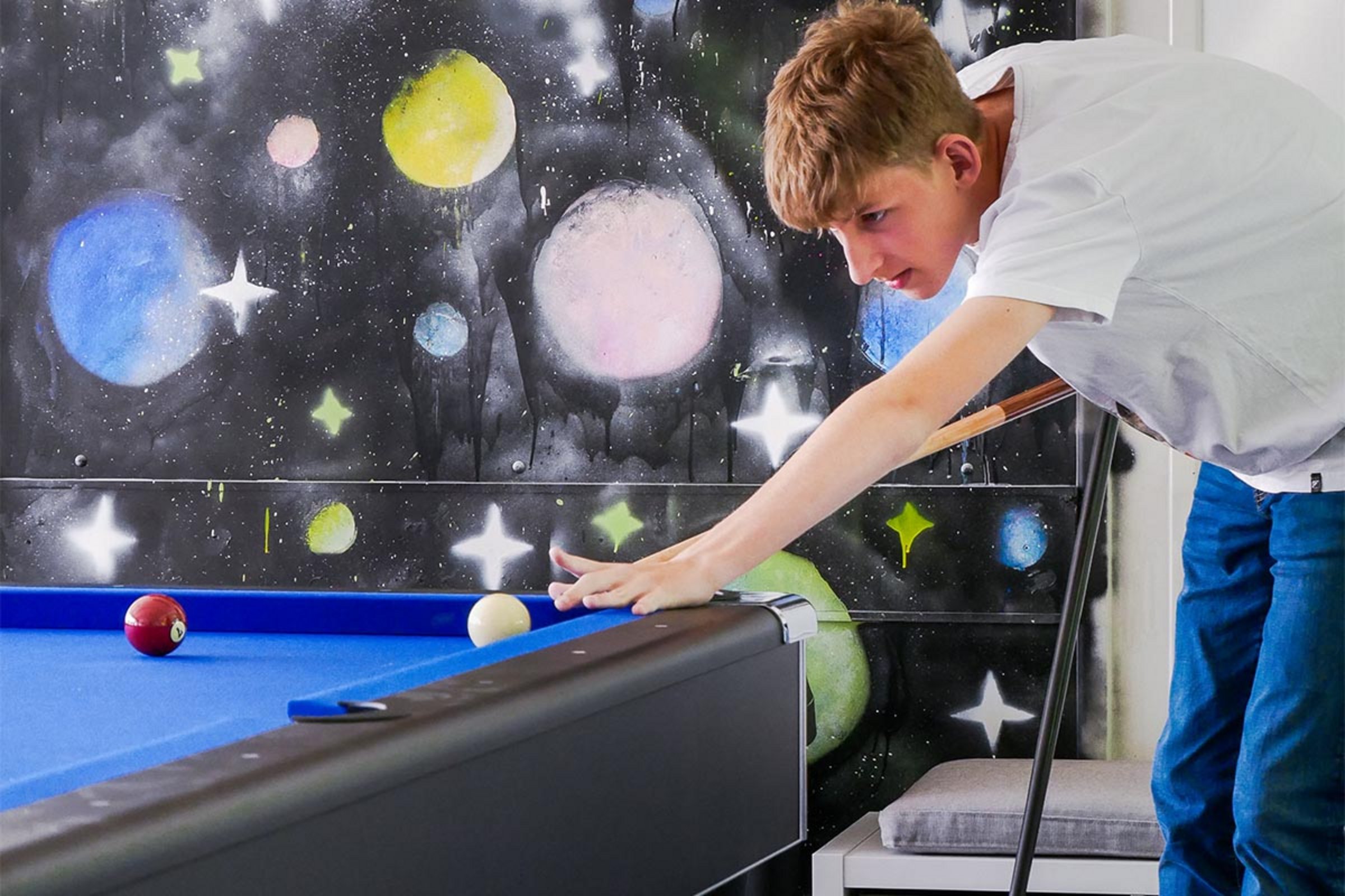 Ein Junge spielt Billard