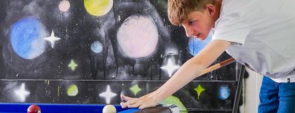 Ein Junge spielt Billard