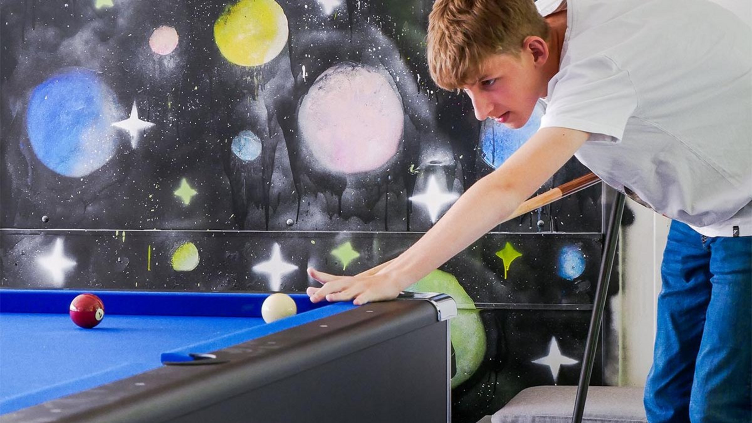 Ein Junge spielt Billard