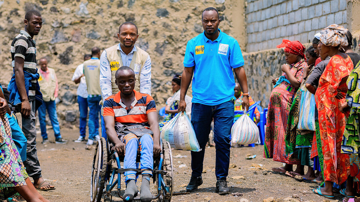 A man in a wheelchair receives food aid