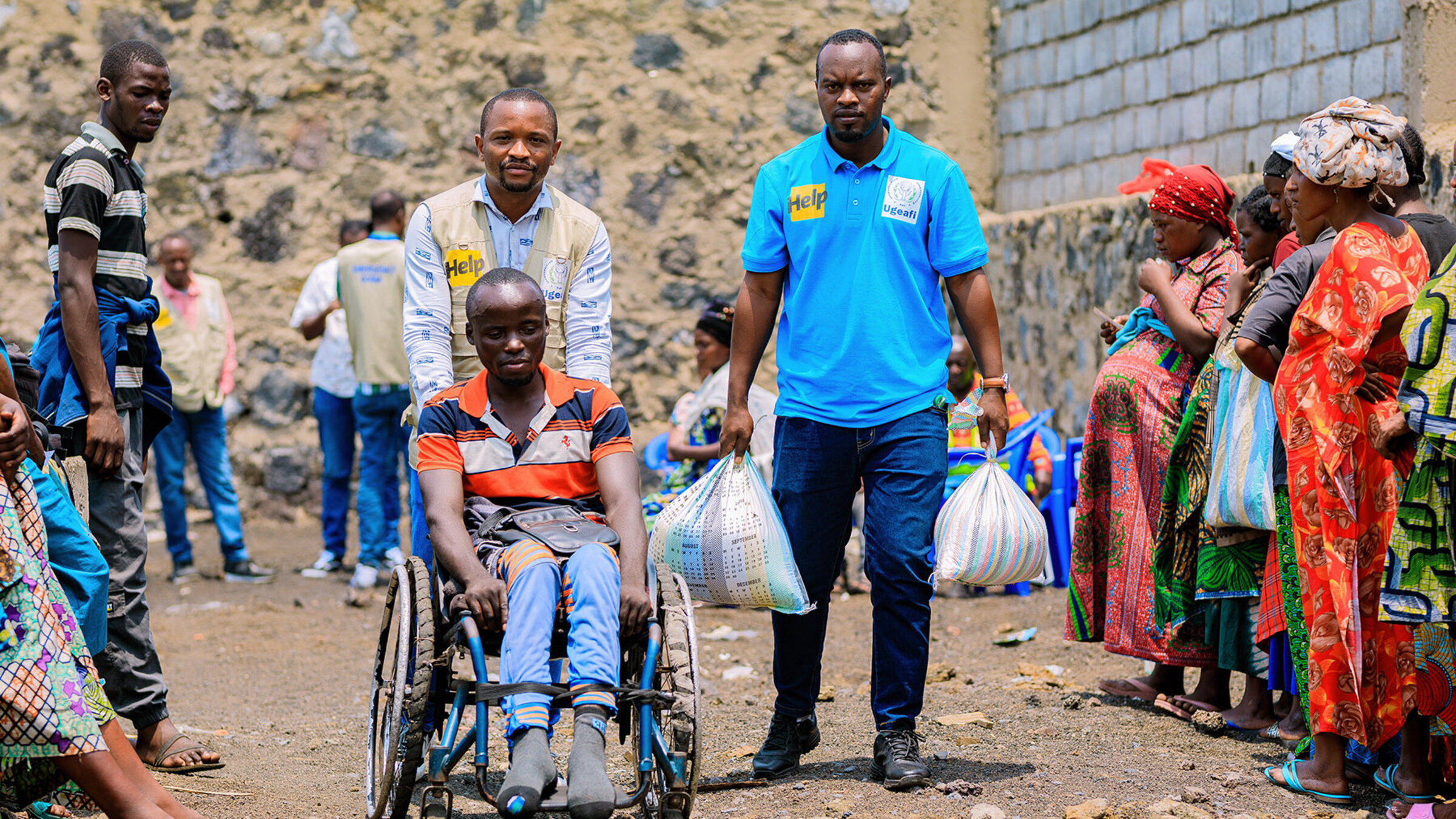 A man in a wheelchair receives food aid