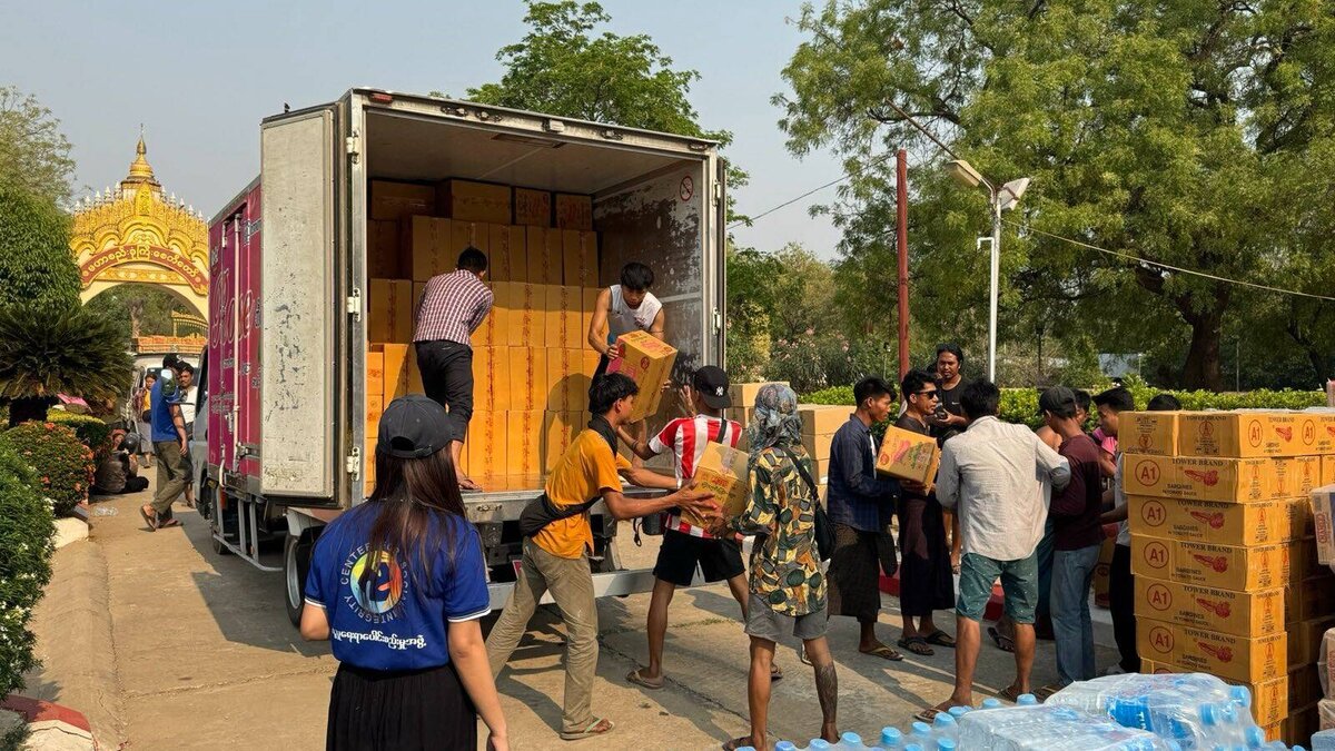 Helpers unload a truck with relief supplies