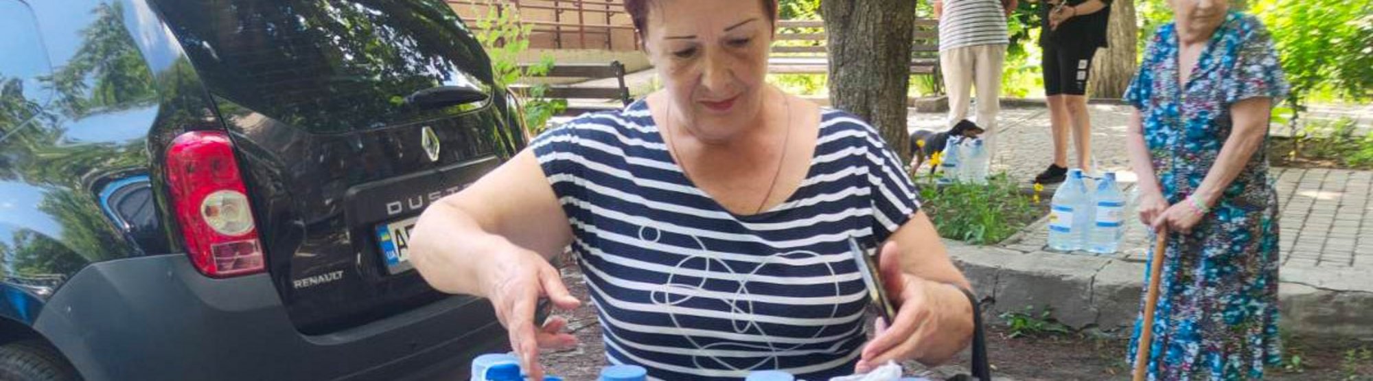Ukrainerin erhält Trinkwasser nach Staudammbruch