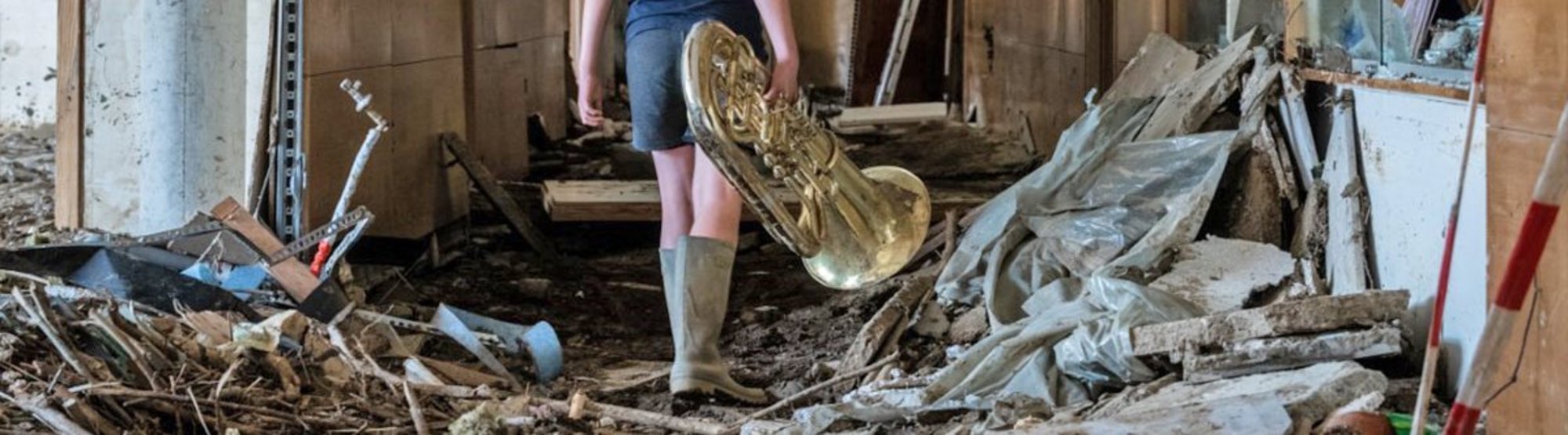 Ein Junge mit einem geretteten Musikinstrument: Das Hochwasser hat im Peter-Joerres-Gymnasium in Bad Neuenahr großen Schaden angerichtet.