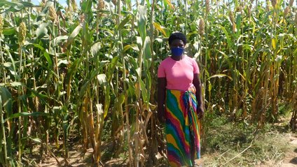 Eine von Help ausgebildete Farmerin vor ihrem Feld