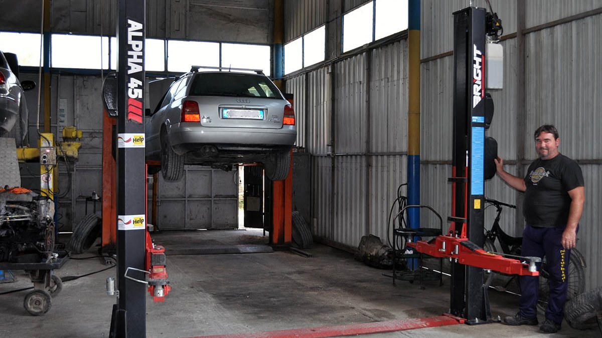 KfZ-Mechaniker Gentian vor seiner neuen Hebebühne, die er dank Help anschaffen konnte. 