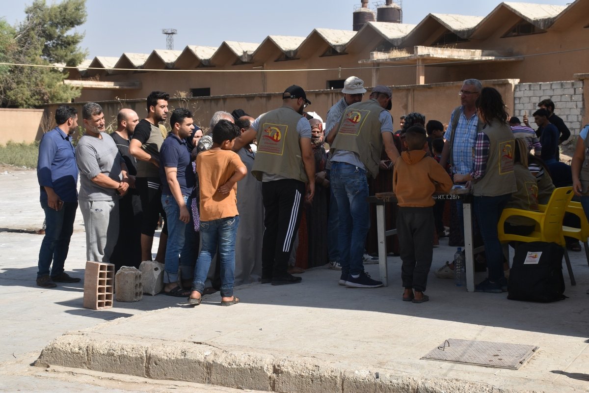 Syrische Familien stehen Schlange für Hilfspakete