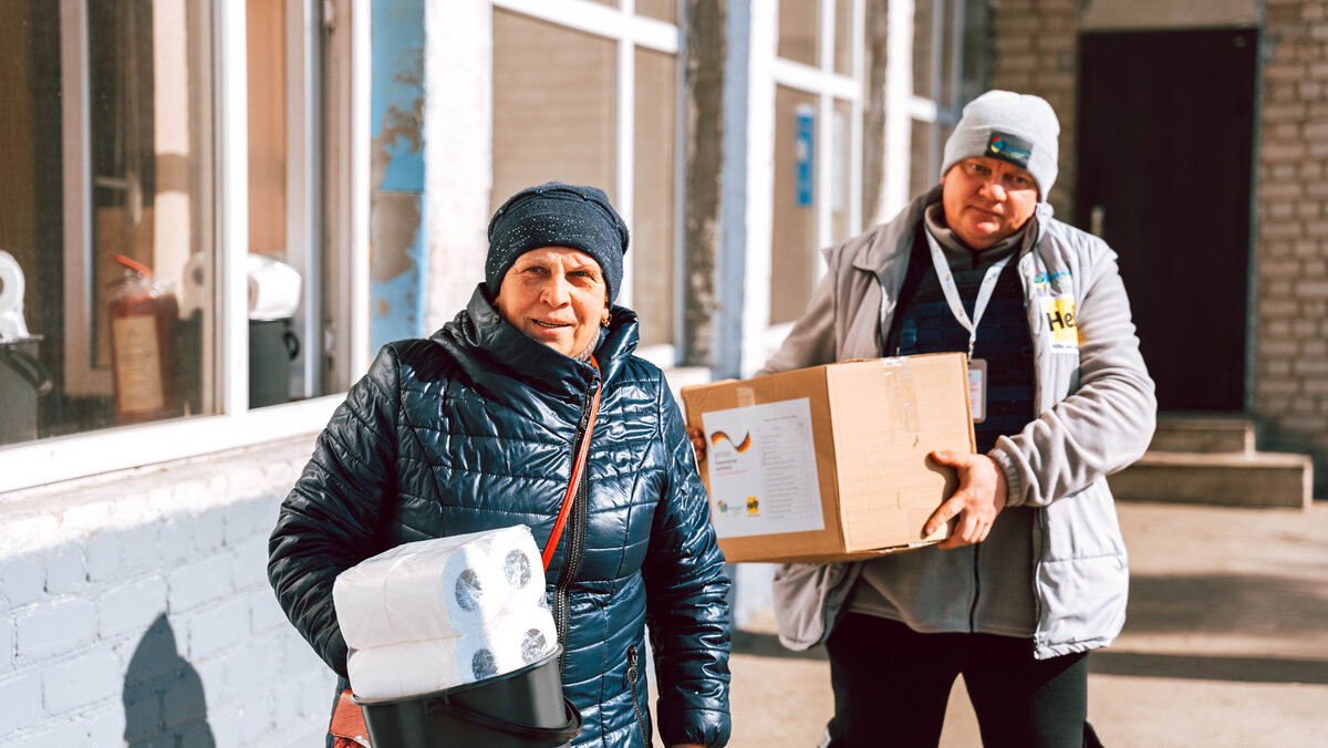 Hilfsgüter für Menschen in der Ukraine Ein humanitärer Helfer und eine ukrainische Dame