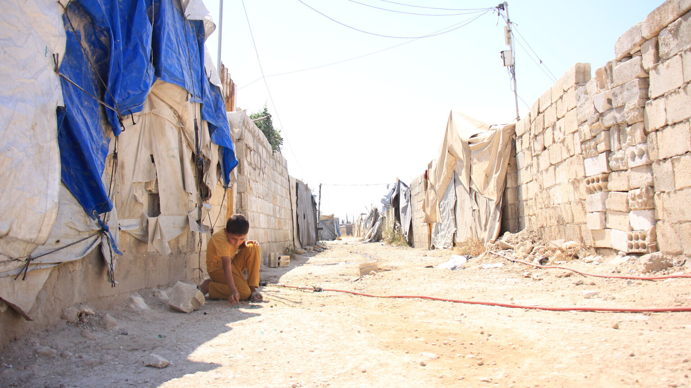 Der Krieg hat seine Spuren hinterlassen: Viele Familien in Syrien leben in provisorischen Unterkünften. Kaputte Dächer sind mit behelfsmäßigen Planen abgedeckt, um sie vor dem Wetter zu schützen.