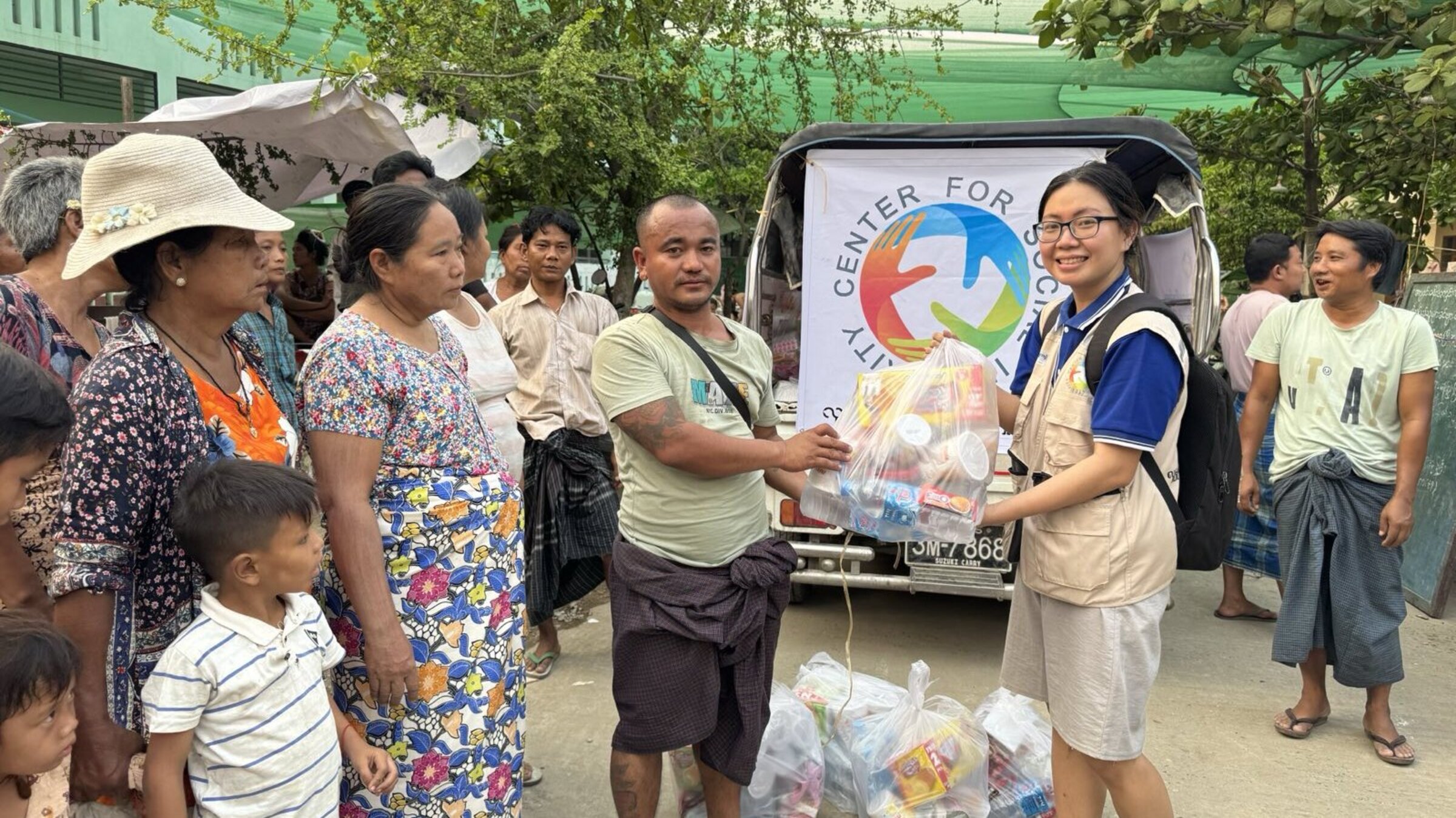 A helper hands a man a bag of food