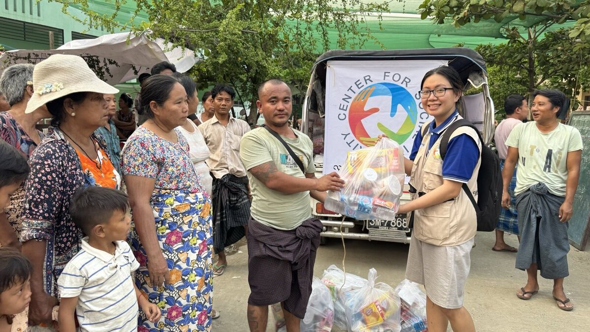 A helper hands a man a bag of food