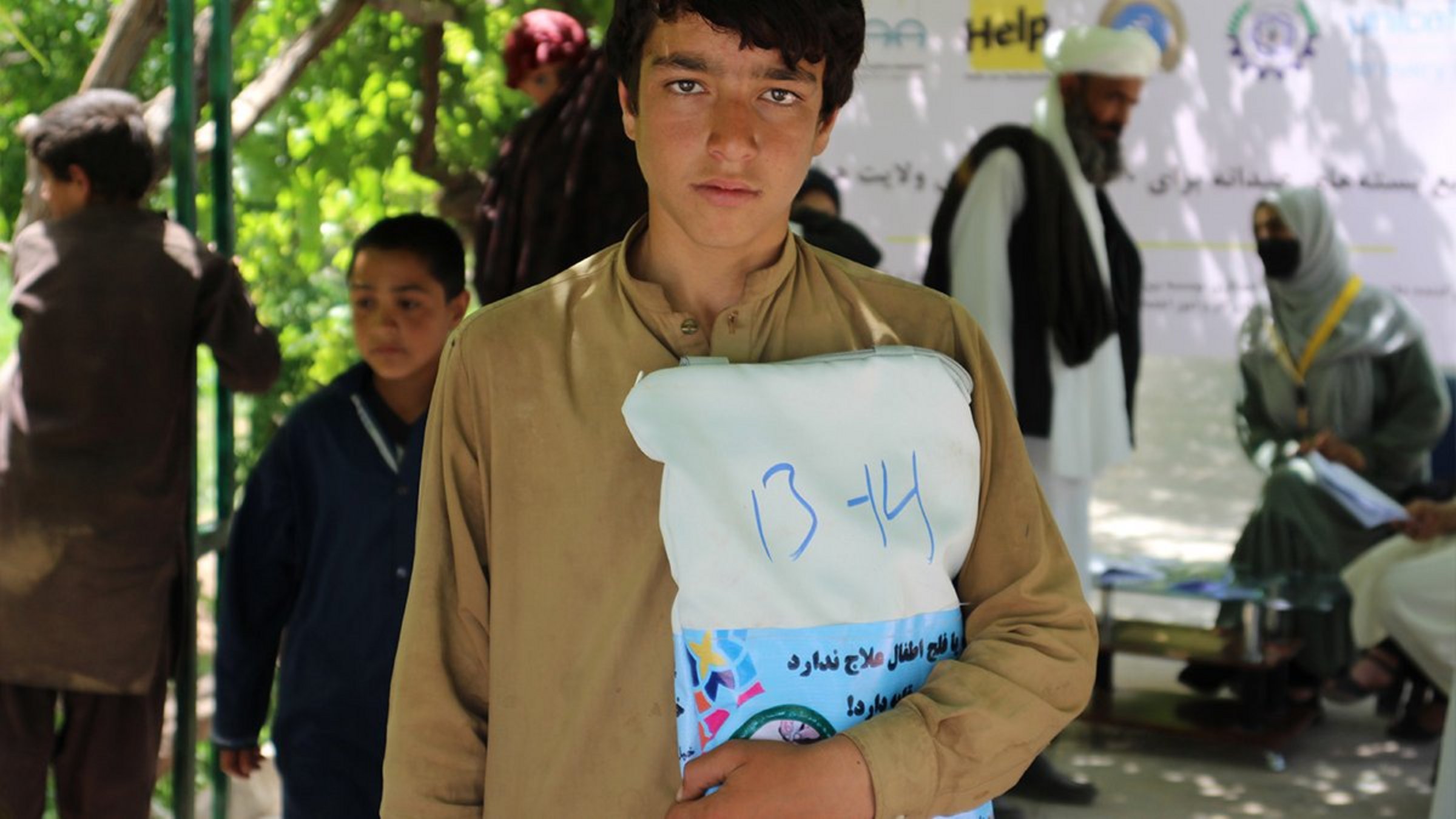 Ein afghanischer Junge erhält Kleidung von Help