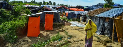 Eine Frau läuft zwischen den selbstgebauten Hütten im Rohingya-Camp in Cox's Bazar
