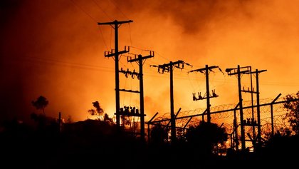 Flammen des Brandes in Moria färben den Nachthimmel