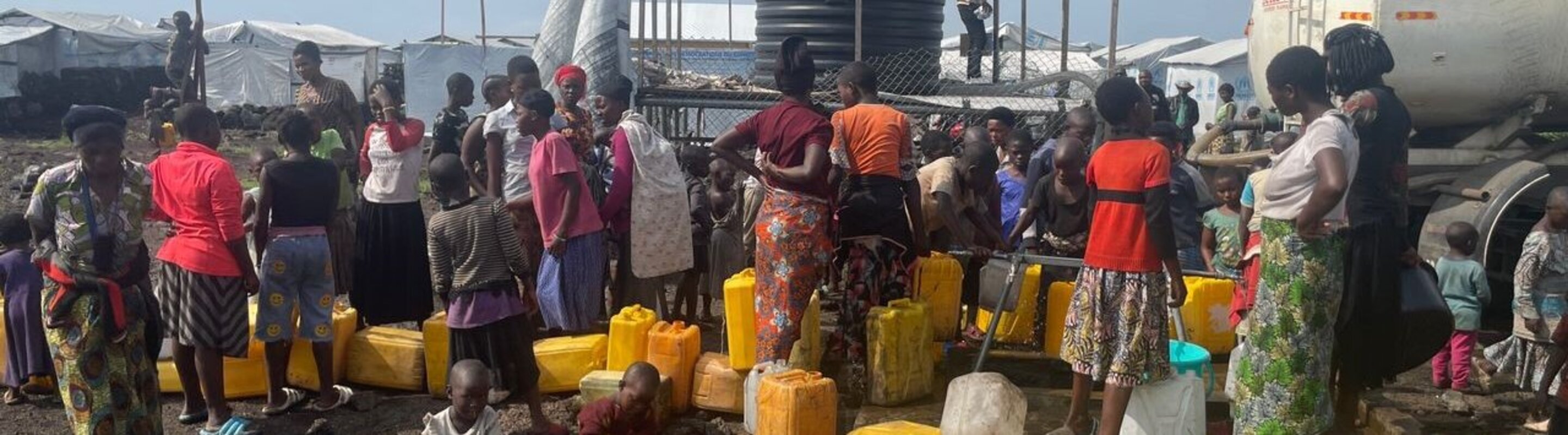 Menschen stehen Schlange für Trinkwasser