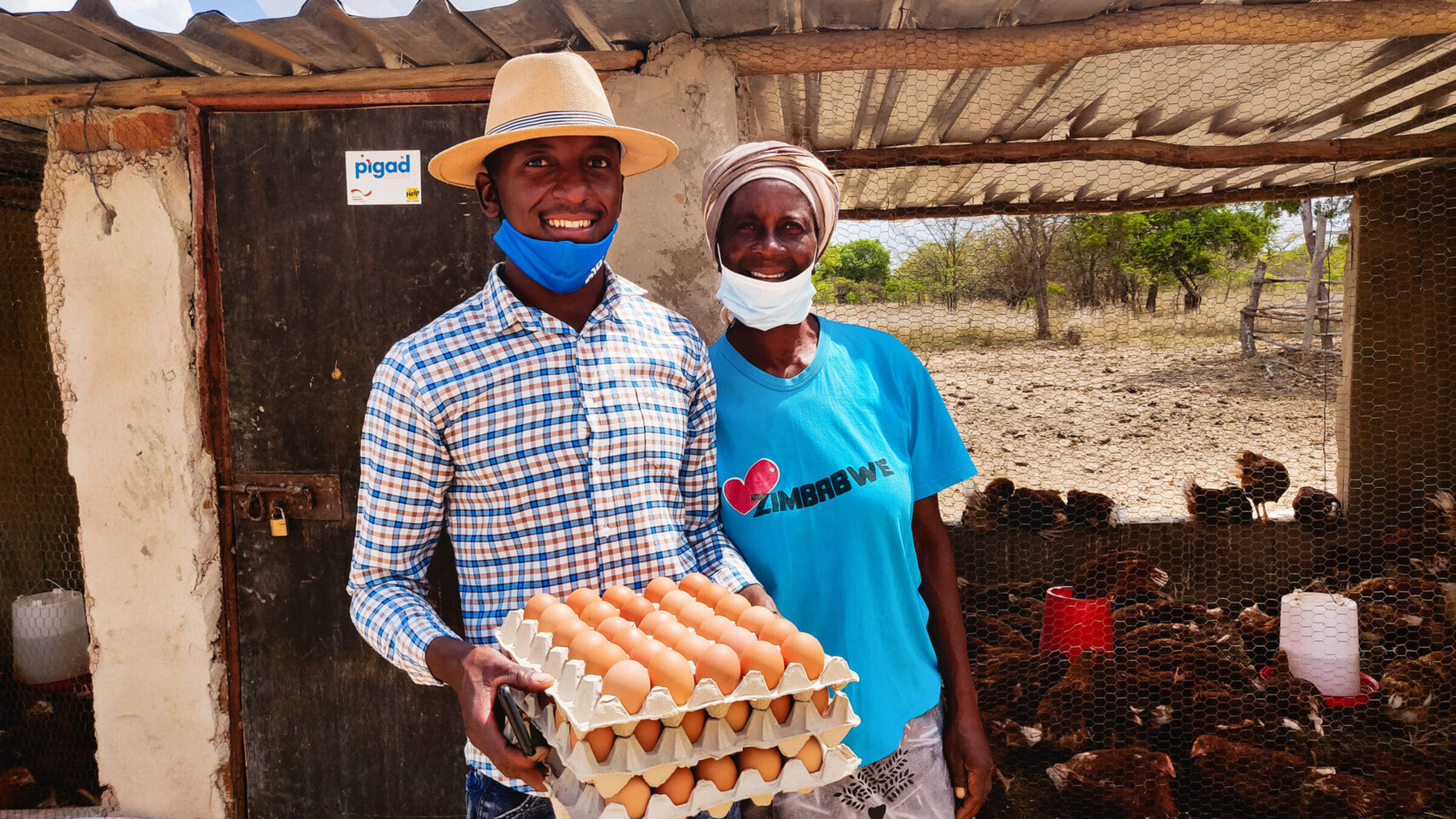 Farmer Kuddakiashe aus Simbabwe steht gemeinsam mit seiner Mutter vor seinem Hühnerstall