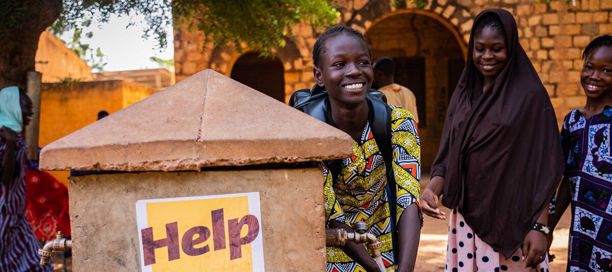 Ein Mädchen wäscht sich die Hände an einem Brunnen in Mali