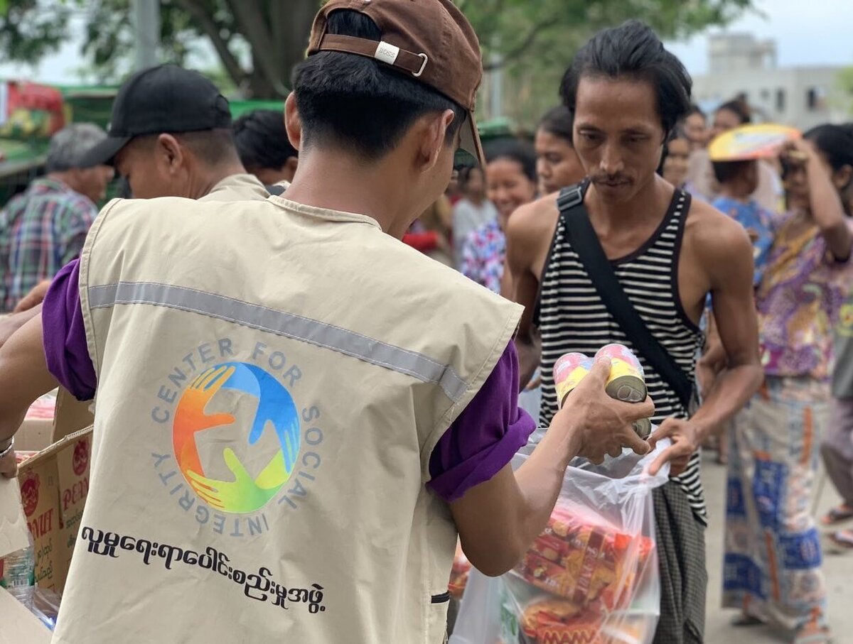 Nothilfe Myanmar: Betroffene des Erdbebens erhalten Hilfsgüter Ein Helfer verteilt Lebensmittel