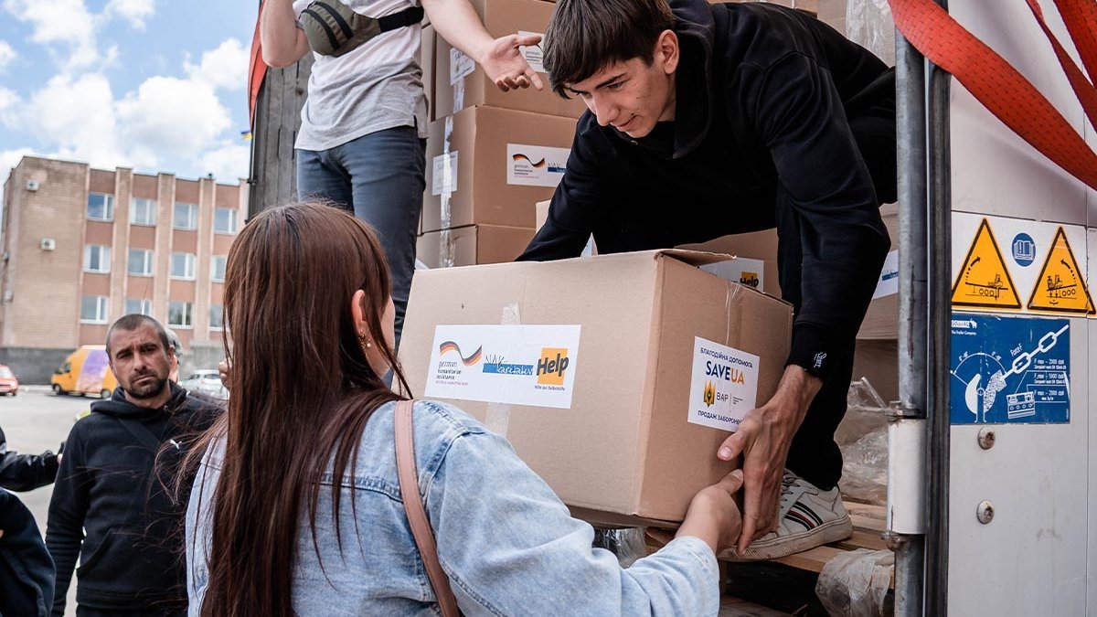 Eine Frau erhält ein Hilfspaket von Help