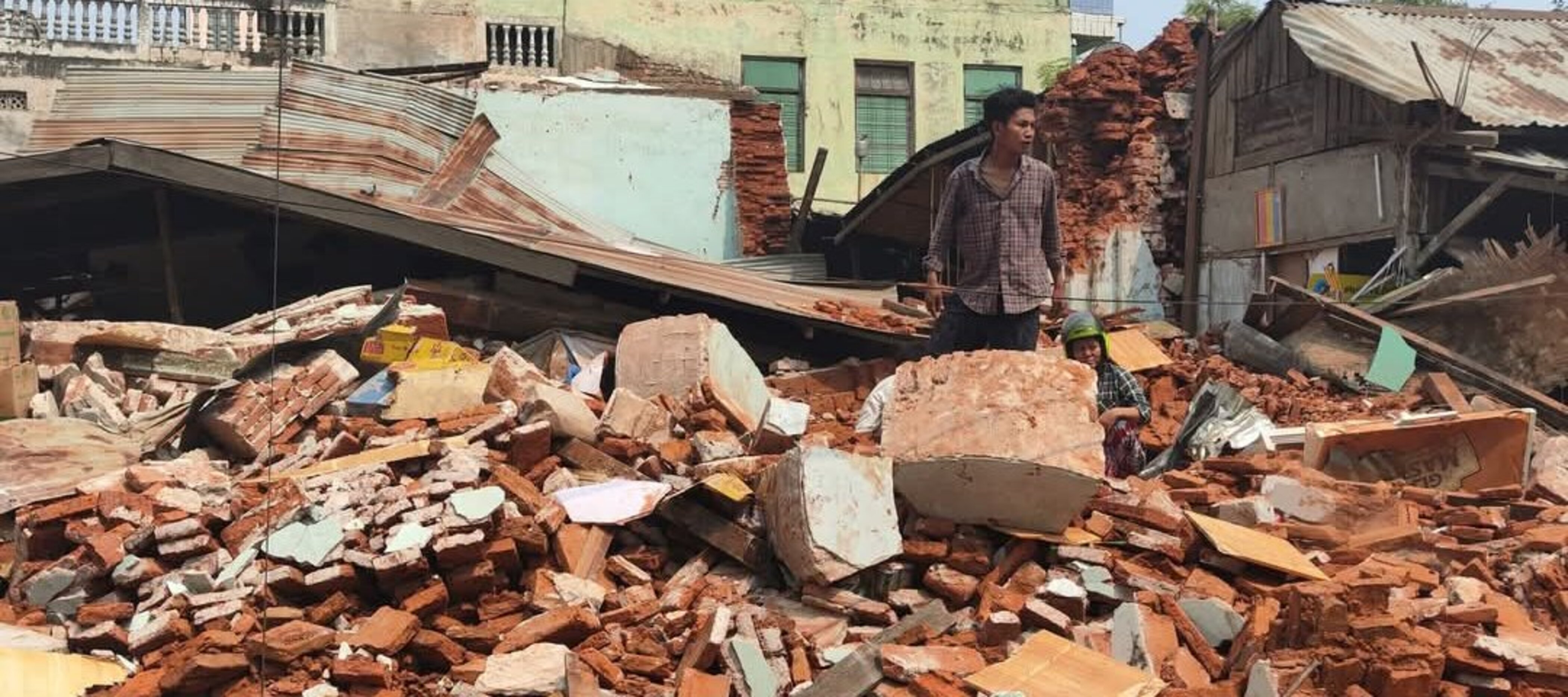 Ein Mann steht in den Trümmern eines Hauses in Myanmar