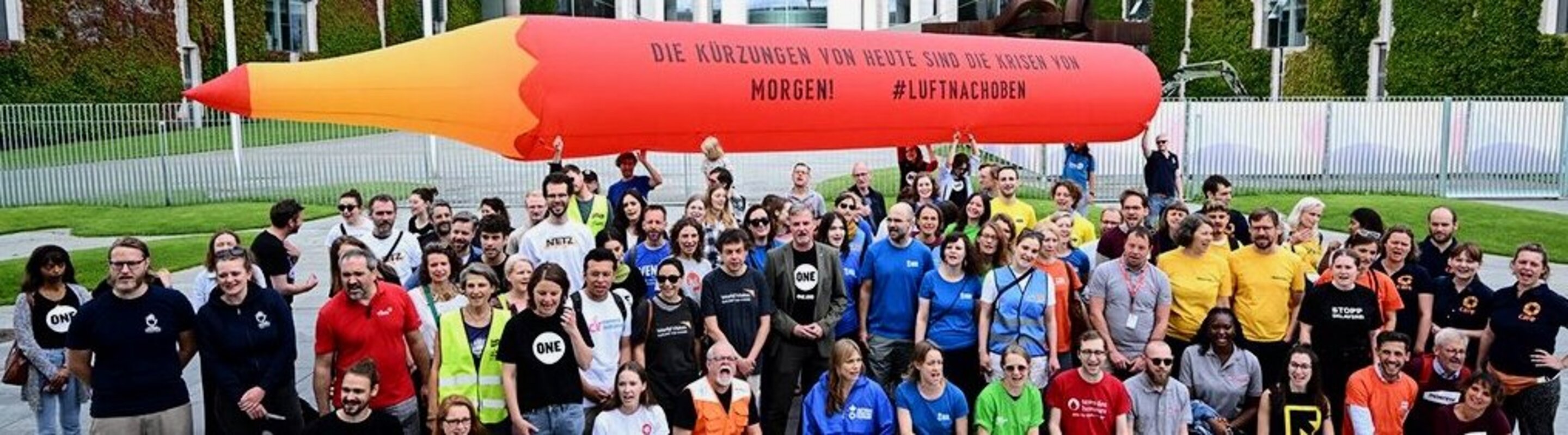 Verteter von Hilfsorganisation ahlten als Protest gegen Kürzungen aufgeblasenen Rotstift in die Luft