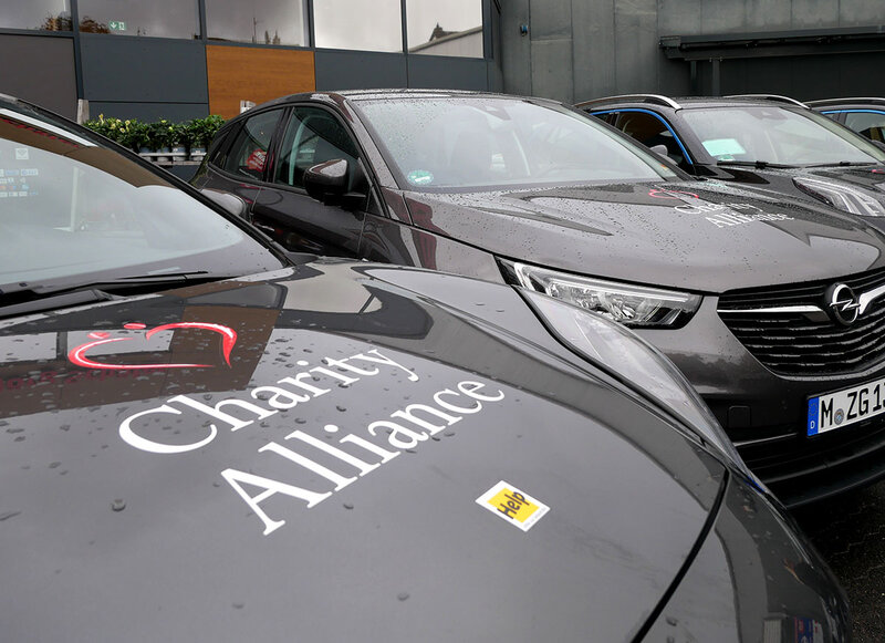 Eine Nahaufnahme einer Motorhaube, auf der die Logos von Help und der Charity Alliance aufgebracht sind