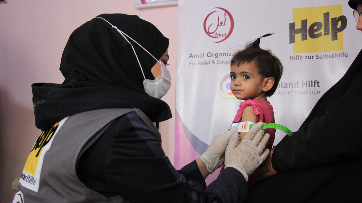 In Syrien erhalten unternährte Kinder kostenlose Behandlungen Eine Ärztin misst den Oberarmumfang eines syrischen Kleinkindes, um dem Grad der Unterernährung festzustellen
