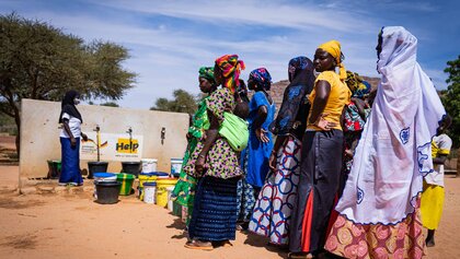 Frauen in Mali stehen Schlange für Trinkwasser
