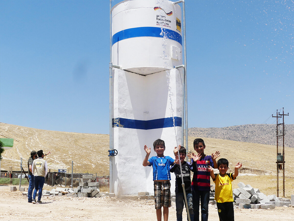 Kinder vor einem Wassertank im Irak