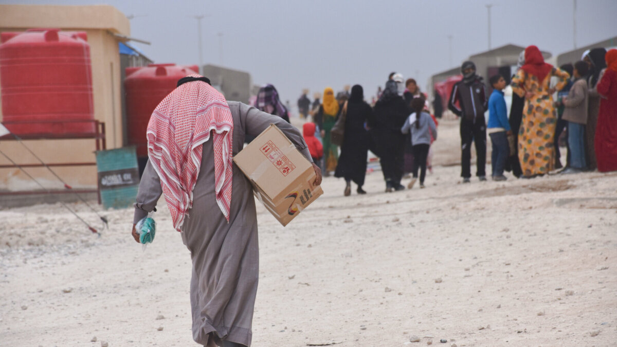 Humanitäre Hilfe Mann mit Hilfspaket in syrischem Flüchtlingslager