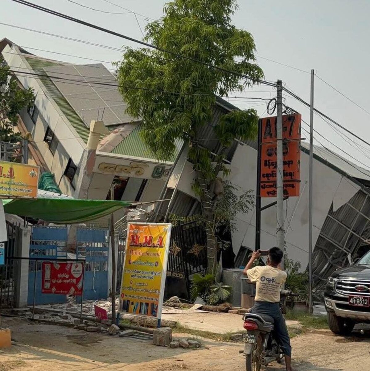 Eingestürzte Häuser nach Erdbeben in Myanmar Ein Mann fotografiert ein eingestürztes Haus in Myanmar