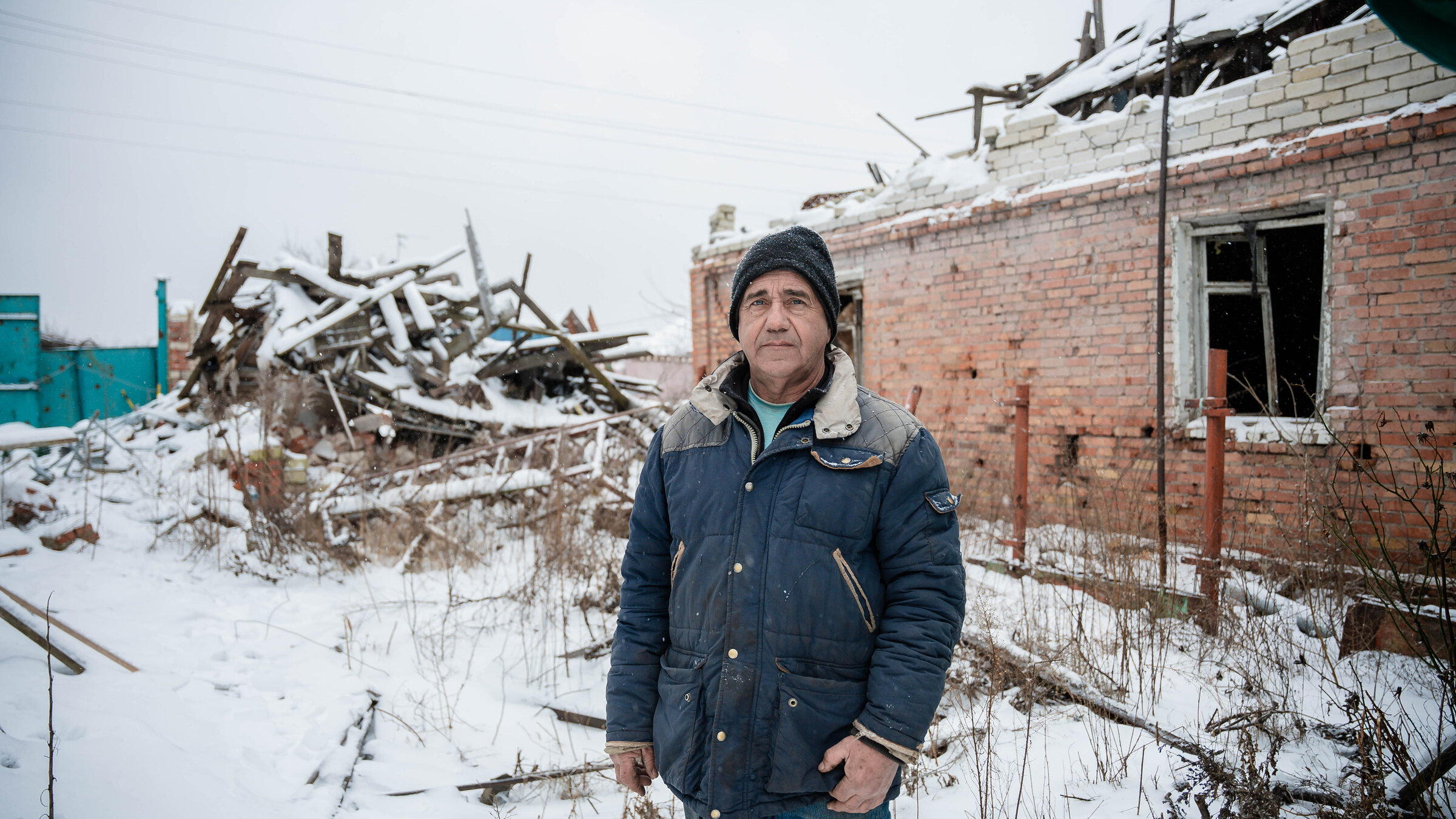 Farmer Yurii in front of the ruins of his farm
