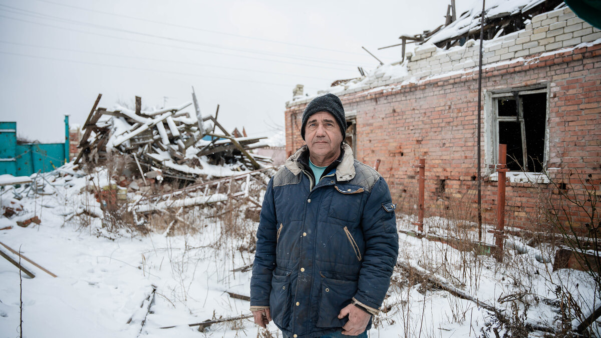 Farmer Yurii in front of the ruins of his farm
