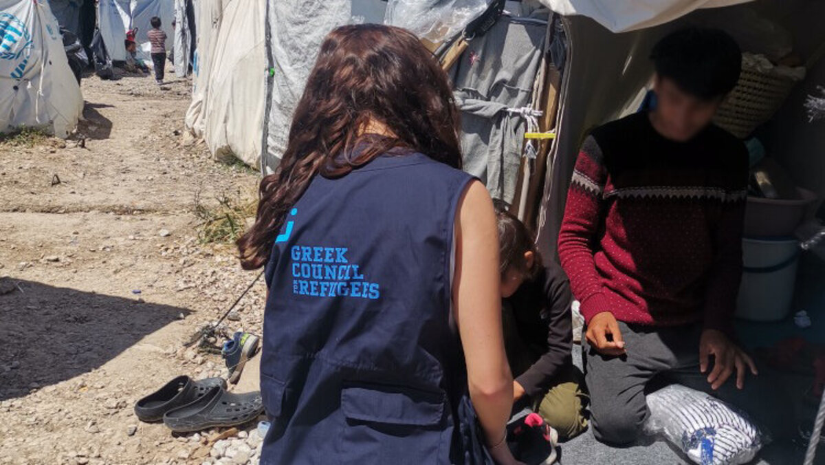 Eine humanitäre Helferin spricht mit einem jungen Geflüchteten in Griechenland