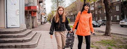 Eine Mutter und ihre Tochter mit einem Trolley voller Hilfsgüter