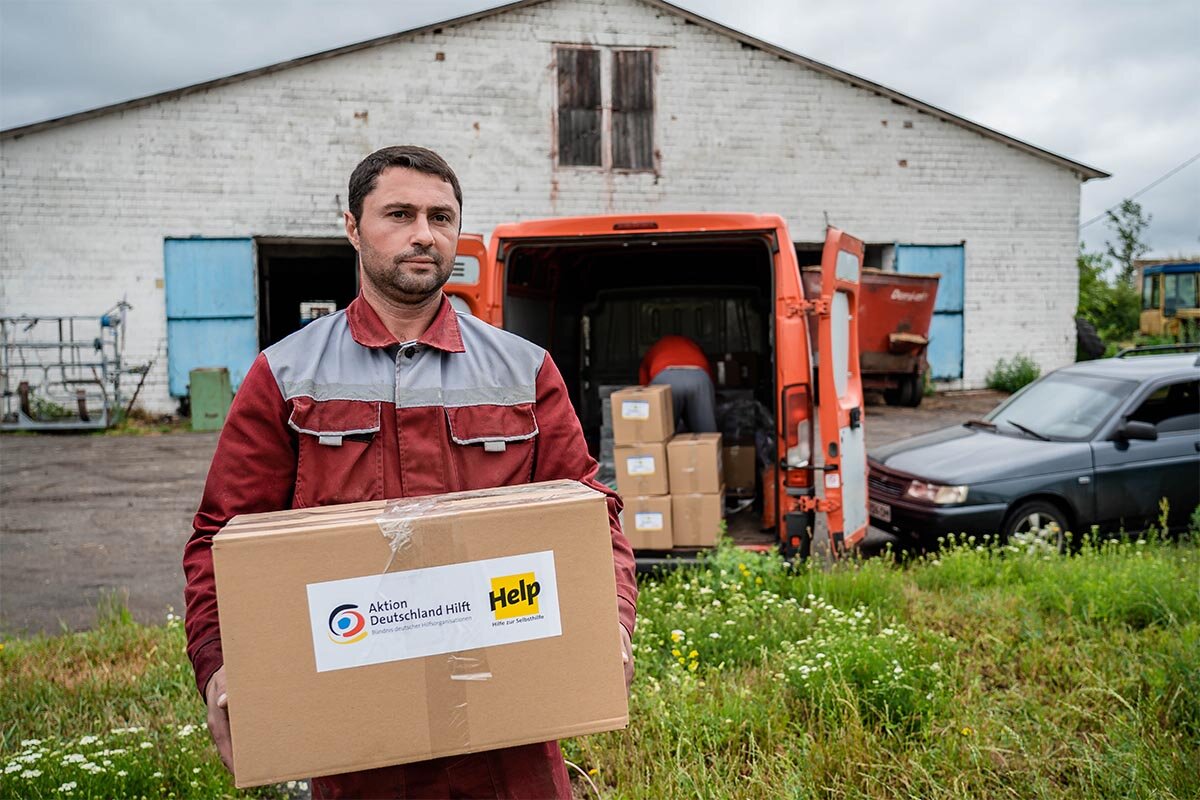 Ein Bauer erhält ein Hilfspaket von Help