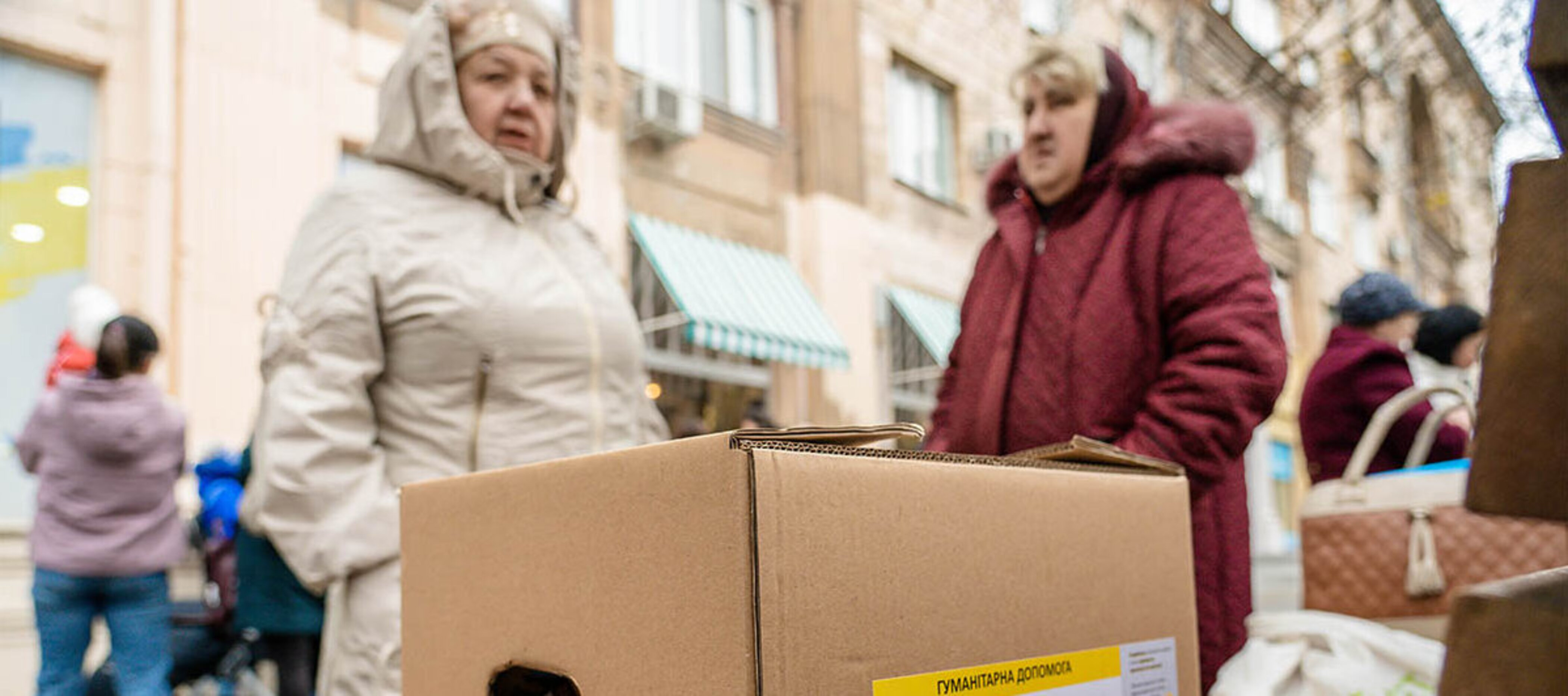 Zwei ältere Damen stehen vor einem Hilfspaket