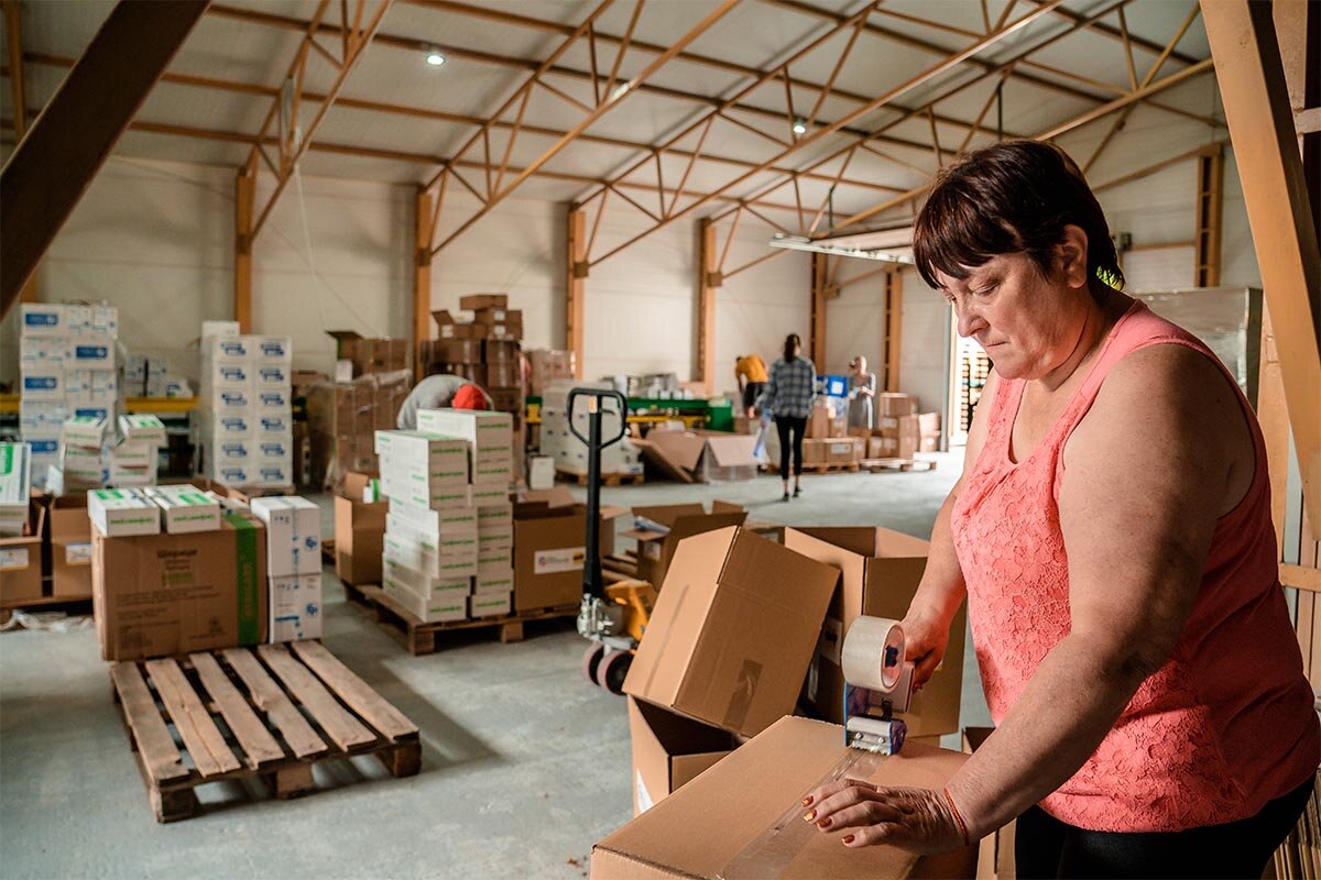 Eine Frau verpackt Tierarzneimittel in Kartons