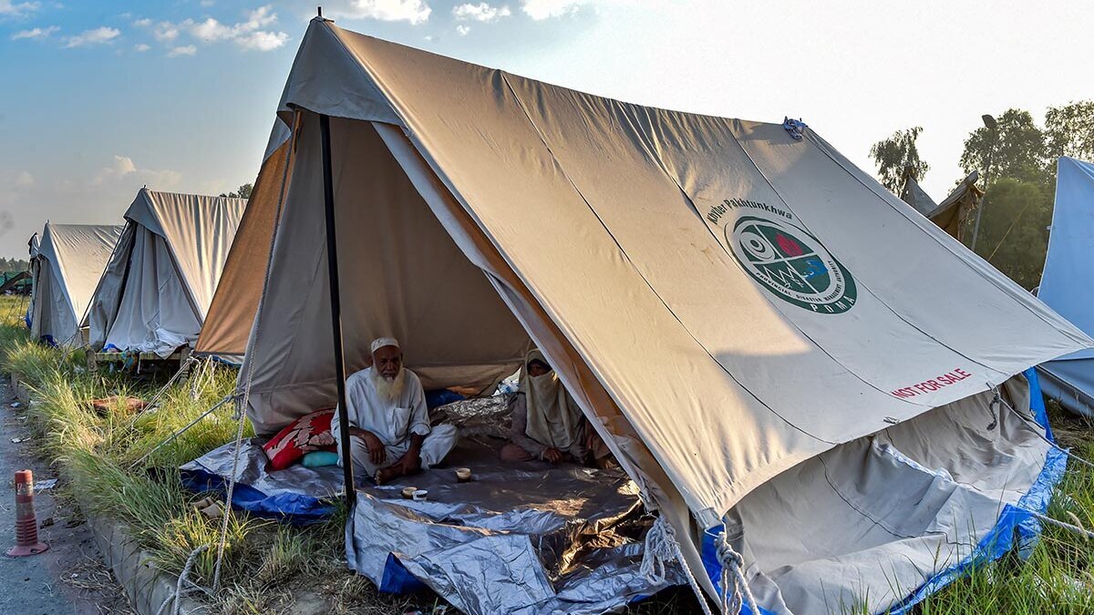 Humanitäre Hilfe sichert Grundbedürfnisse, beispielsweise Notunterkünfte Ein pakistanischer Mann sitzt in einem Zelt