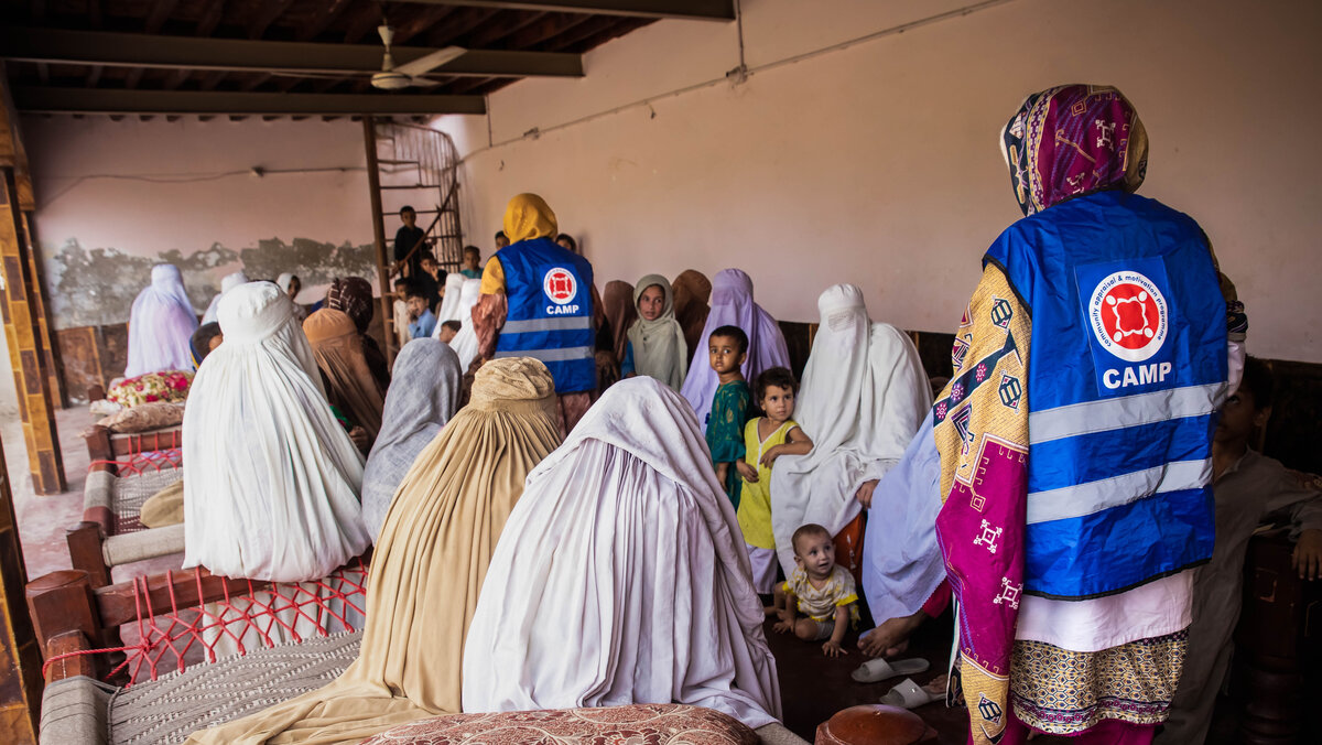 Zwei humanitäre Helferinnen im Gespräch mit pakistanischen Frauen