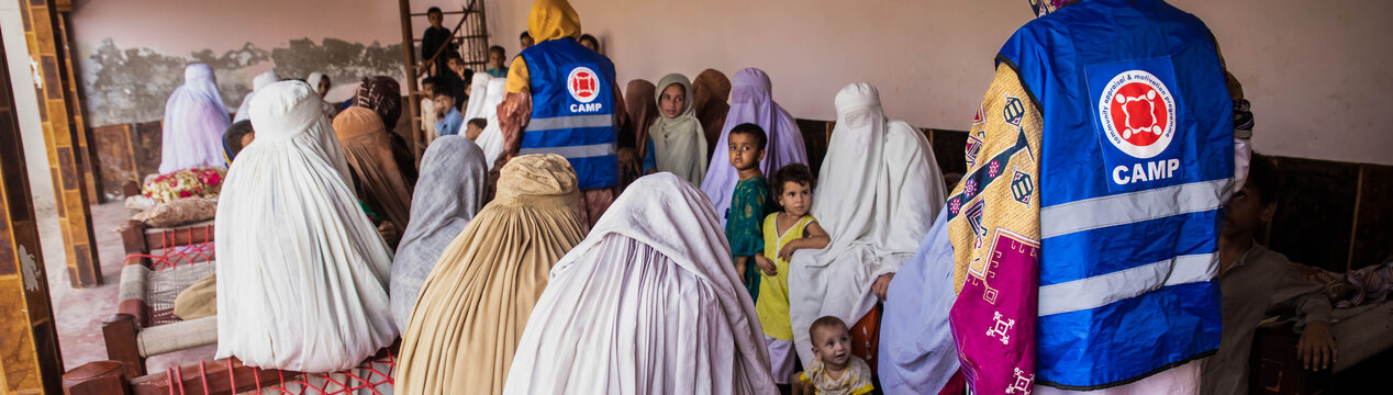 Zwei humanitäre Helferinnen im Gespräch mit pakistanischen Frauen