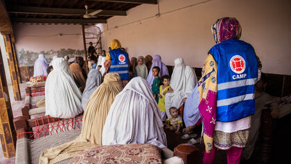 Zwei humanitäre Helferinnen im Gespräch mit pakistanischen Frauen