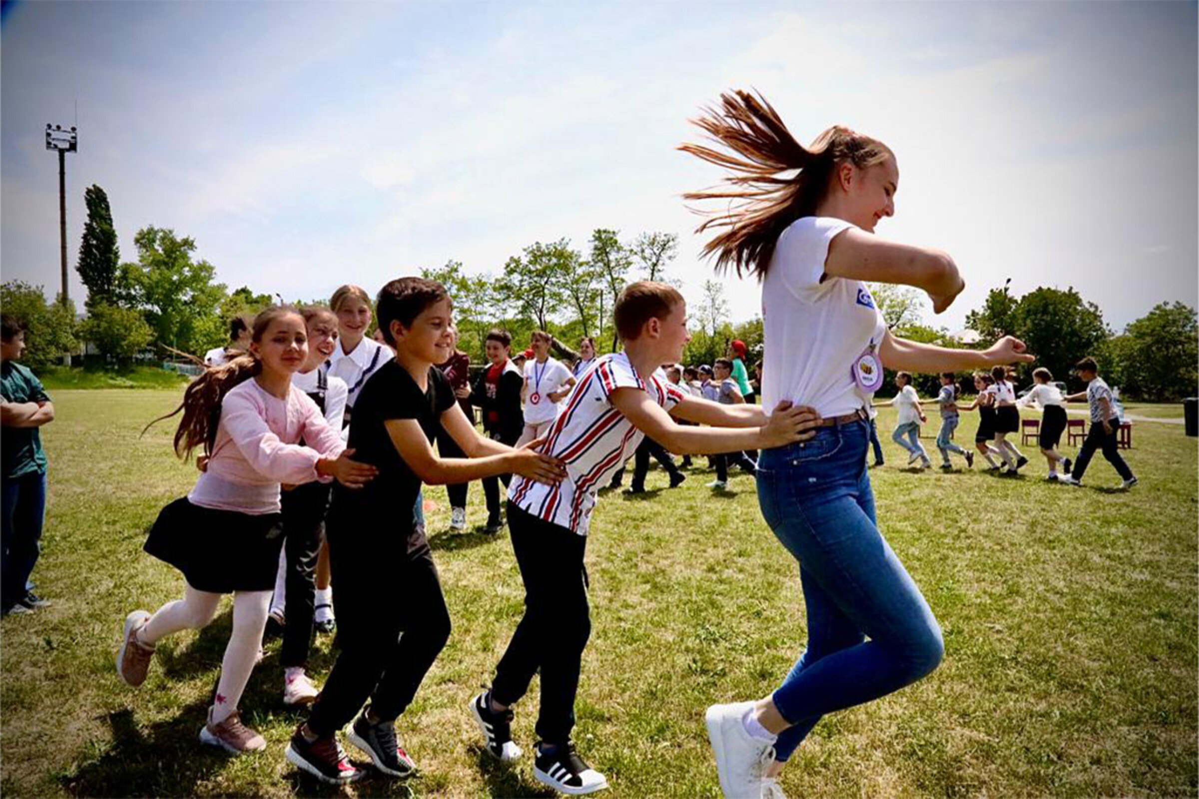 Ukrainische Kinder spielen gemeinsam auf einer grünen Wiese 